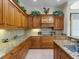 Spacious kitchen with granite countertops, custom wood cabinetry, and decorative accents at 9501 Tavistock Rd, Orlando, FL 32827