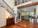 Elegant foyer with wood floors, staircase with iron railings, and an archway to the living room at 9501 Tavistock Rd, Orlando, FL 32827