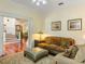 Comfortable living room with plush sofa, ottoman, and a glimpse of the staircase and hallway at 9501 Tavistock Rd, Orlando, FL 32827