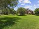 View of beautiful brick home surrounded by well maintained green lawn and shady mature trees at 9501 Tavistock Rd, Orlando, FL 32827