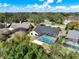 Aerial view showcasing the property with its screened-in pool, spacious backyard, and mature trees at 10012 Silver Bluff Dr, Leesburg, FL 34788