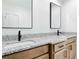 Bathroom featuring a wood vanity with granite countertop and two mirrors at 10012 Silver Bluff Dr, Leesburg, FL 34788