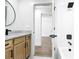Bathroom featuring a wood vanity with granite countertop, view into the shower room and bedroom at 10012 Silver Bluff Dr, Leesburg, FL 34788