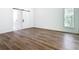 Bedroom featuring wood laminate flooring, a window, and a closet with a sliding barn door at 10012 Silver Bluff Dr, Leesburg, FL 34788