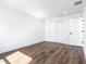 A simple bedroom with wood laminate floors, white walls, and double door closet at 10012 Silver Bluff Dr, Leesburg, FL 34788