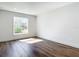 Clean bedroom features wood floors, white trim, and one window providing natural light at 10012 Silver Bluff Dr, Leesburg, FL 34788