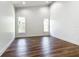 This empty bedroom offers wood floors, white walls and trim, and two windows that bring in lots of natural light at 10012 Silver Bluff Dr, Leesburg, FL 34788