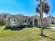 Charming home featuring a well-manicured lawn and stucco facade and well-lit by large windows at 10012 Silver Bluff Dr, Leesburg, FL 34788