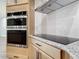 Stainless steel oven and cooktop appliances, granite countertops, and wooden cabinets are the stars of this modern kitchen at 10012 Silver Bluff Dr, Leesburg, FL 34788