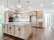 Modern kitchen with a spacious granite island, lots of wooden cabinet space, and stainless steel appliances at 10012 Silver Bluff Dr, Leesburg, FL 34788