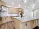 Bright kitchen features an island with a sink and granite countertops, modern appliances and wooden cabinets at 10012 Silver Bluff Dr, Leesburg, FL 34788