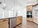 A stainless steel dishwasher and sink are featured in a kitchen island with granite countertops and modern appliances at 10012 Silver Bluff Dr, Leesburg, FL 34788