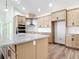 This light and airy kitchen offers modern appliances, granite countertops, a kitchen island and wooden cabinets at 10012 Silver Bluff Dr, Leesburg, FL 34788