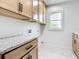 Convenient laundry room features ample cabinet space, granite countertops, and a window for natural light at 10012 Silver Bluff Dr, Leesburg, FL 34788