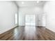 Open living room with a sliding glass door, a window and wood laminate floors at 10012 Silver Bluff Dr, Leesburg, FL 34788