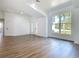 Open-concept living room with hard surface floors and a large window with plenty of natural light at 10012 Silver Bluff Dr, Leesburg, FL 34788