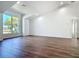 Bright living room featuring wood-look floors and a large window letting in plenty of natural light at 10012 Silver Bluff Dr, Leesburg, FL 34788