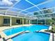 Enjoy the screened-in pool with a sunny blue liner surrounded by a concrete patio and lush landscaping at 10012 Silver Bluff Dr, Leesburg, FL 34788