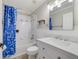 Bathroom with a blue shower curtain, a toilet, a built in bathtub, and a marble topped sink at 1024 Harbor Hill St, Winter Garden, FL 34787