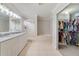 Bright bathroom featuring a double sink vanity, a glass-enclosed shower, and a soaking tub with tiled surround at 1024 Harbor Hill St, Winter Garden, FL 34787