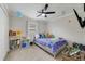 Bedroom with a ceiling fan, toys, books, and a bed with a blue comforter and multiple pillows at 1024 Harbor Hill St, Winter Garden, FL 34787