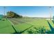 Bright outdoor tennis court with well-maintained green surface and clear blue skies in a luxurious golf community at 1024 Harbor Hill St, Winter Garden, FL 34787
