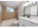 Bathroom with tiled shower and tub, quartz vanity, modern fixtures, and natural light at 103 Ford Ave, Altamonte Springs, FL 32701