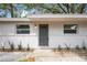 Charming single-story home with a gray front door, white brick, and freshly landscaped with green plants at 103 Ford Ave, Altamonte Springs, FL 32701