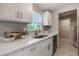 Modern kitchen featuring white cabinets, a stainless steel sink, and quartz countertops at 103 Ford Ave, Altamonte Springs, FL 32701