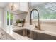 Modern kitchen sink with stainless steel faucet and quartz countertop, complemented by natural light at 103 Ford Ave, Altamonte Springs, FL 32701