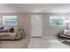 Bright living room featuring a comfortable couch, tiled floors, and a view of the front yard through the windows at 103 Ford Ave, Altamonte Springs, FL 32701