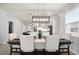 Contemporary dining room features stylish seating, an elegant chandelier, and a view into the modern kitchen at 12064 Encore At Ovation Way, Winter Garden, FL 34787