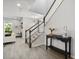 Stylish foyer with staircase, accent table, and view into a cozy living area creates a welcoming entrance at 12064 Encore At Ovation Way, Winter Garden, FL 34787