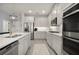 Modern kitchen featuring stainless steel appliances, white cabinetry, and a spacious island with stylish pendant lighting at 12064 Encore At Ovation Way, Winter Garden, FL 34787