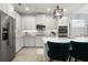 Well-lit kitchen with stainless steel appliances, white cabinets, and a central island with barstool seating at 12064 Encore At Ovation Way, Winter Garden, FL 34787