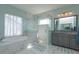 Bright bathroom featuring a glass shower, a soaking tub, and a vanity with gray cabinets at 15672 Shorebird Ln, Winter Garden, FL 34787