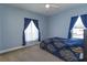 Blue-themed bedroom boasts a bed with ornate patterned bedding, complemented by matching curtains at 15672 Shorebird Ln, Winter Garden, FL 34787