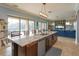 Kitchen island with seating and stainless steel dishwasher open to the living room with pool views at 15672 Shorebird Ln, Winter Garden, FL 34787
