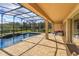Relaxing screened-in pool area with a waterfall feature and cozy outdoor seating at 15672 Shorebird Ln, Winter Garden, FL 34787