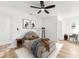 This primary bedroom features a ceiling fan, neutral paint, wood flooring, and ensuite bathroom at 1597 Lansfield Ave, Deltona, FL 32738