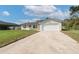 Charming single-story home featuring a well-manicured front yard and a large driveway at 1597 Lansfield Ave, Deltona, FL 32738