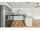Open kitchen featuring stainless appliances, granite counters and view of the new wood floors at 1597 Lansfield Ave, Deltona, FL 32738