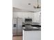 Updated kitchen with stainless steel appliances, white cabinets, and dark countertops at 1597 Lansfield Ave, Deltona, FL 32738
