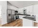 Modern kitchen with stainless steel appliances, granite countertops, and sleek white cabinetry at 1597 Lansfield Ave, Deltona, FL 32738