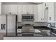 Updated kitchen boasts stainless steel appliances, white cabinets, and granite countertops at 1597 Lansfield Ave, Deltona, FL 32738
