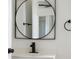 Modern bathroom vanity features a black faucet, round mirror, and wall-mounted towel rack at 1597 Lansfield Ave, Deltona, FL 32738