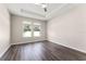 Spacious bedroom features tray ceiling, ceiling fan, two windows and vinyl plank flooring at 1598 Barberry Dr, Kissimmee, FL 34744