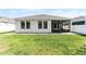 Beautiful home exterior with a screened-in patio and expansive manicured lawn at 1598 Barberry Dr, Kissimmee, FL 34744