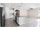 Open concept kitchen and living area with modern tile flooring and a kitchen island at 1598 Barberry Dr, Kissimmee, FL 34744