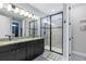 Bathroom features a double vanity, granite counters, and a sleek glass-enclosed shower at 1763 Standing Rock Cir, Oakland, FL 34787